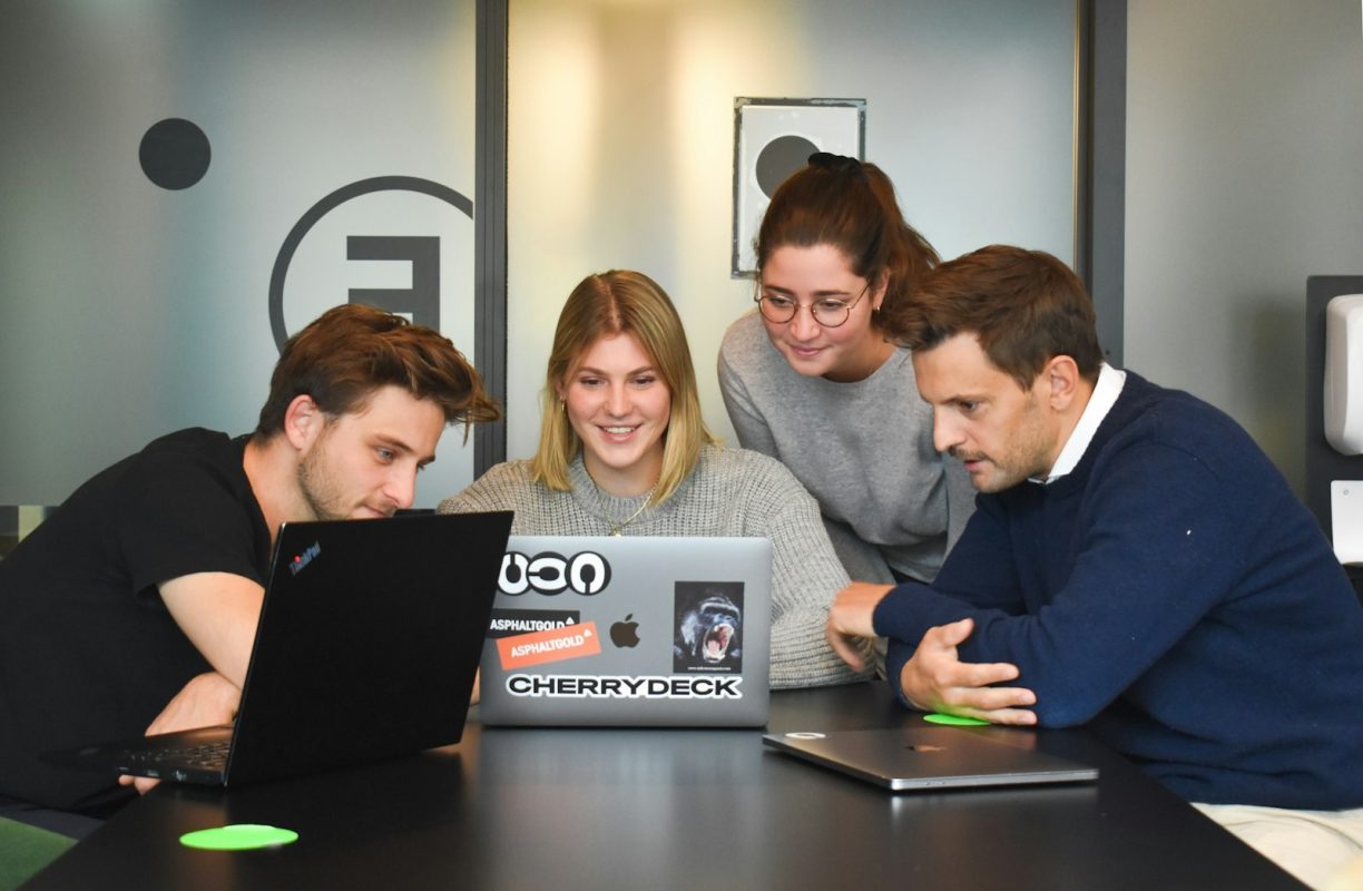 Quatro pessoas colaborando no escritório, planejamento de campanha do analista de marketing
