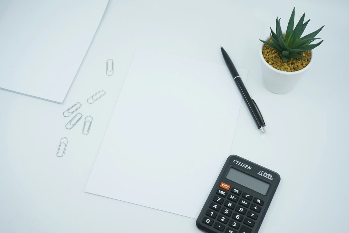 Calculadora de rescisão: calculadora preta e caneta sobre papel para conferir as verbas