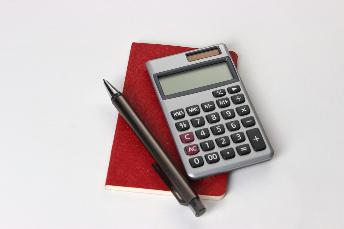 Calculadora de salário líquido: calculadora e caneta sobre a mesa para conferir o holerite