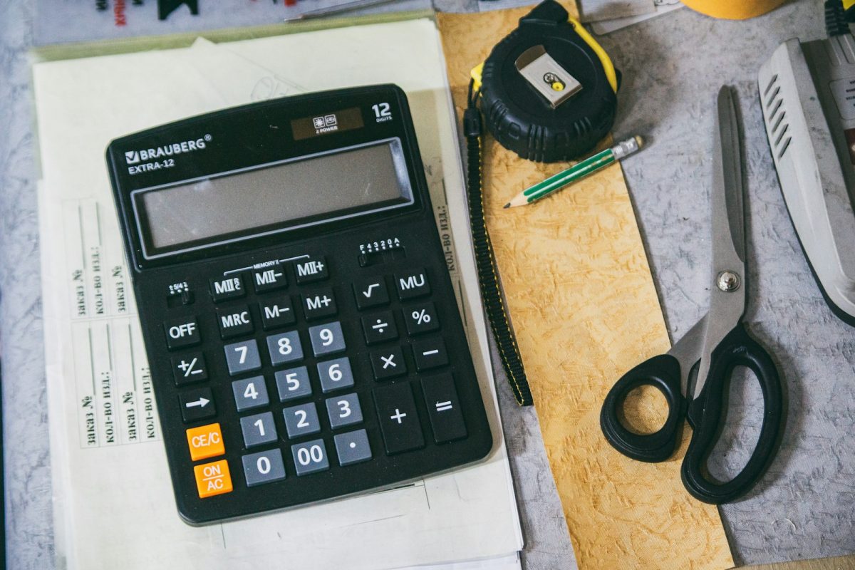 Calculadora de salário líquido com material de escritório para calcular INSS e IRRF de 2026