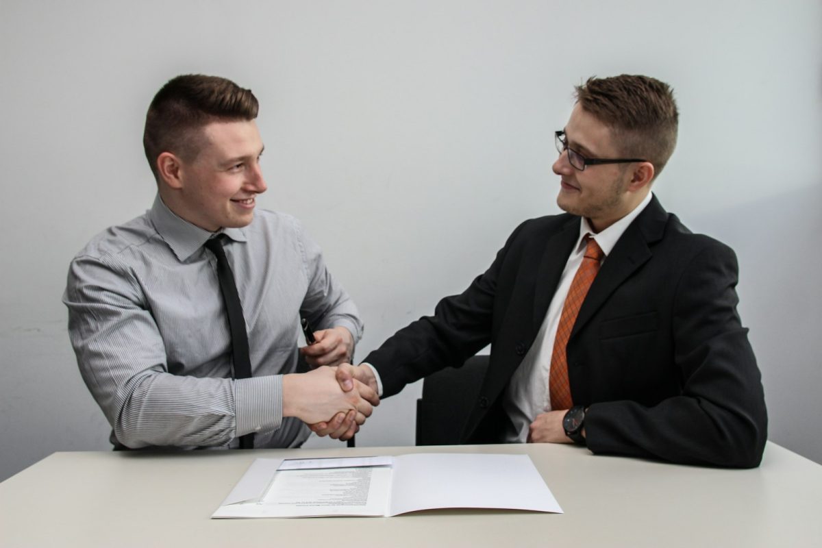Como se comportar em uma entrevista de emprego: aperto de mãos e sorriso na chegada