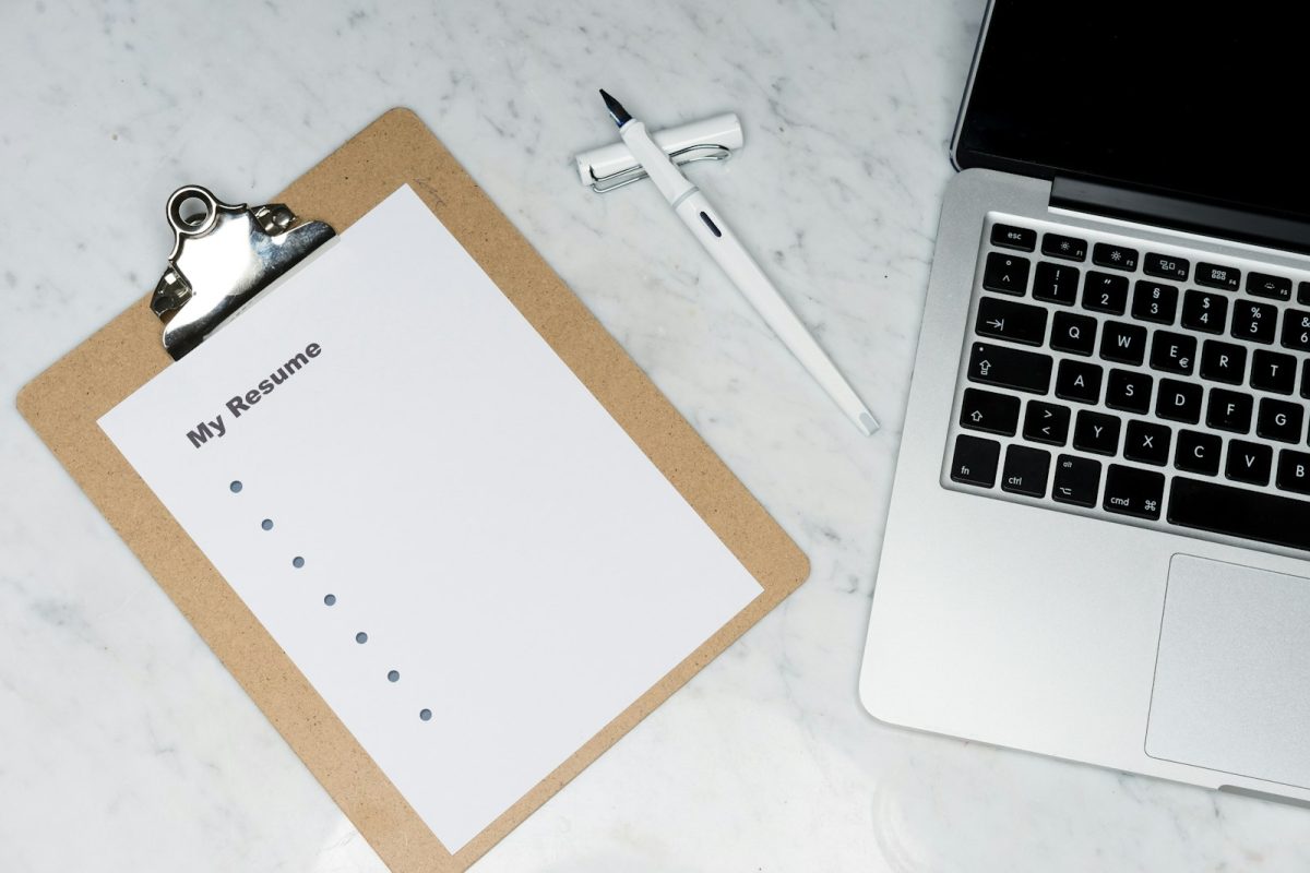 Considerações finais do currículo: currículo impresso ao lado do notebook