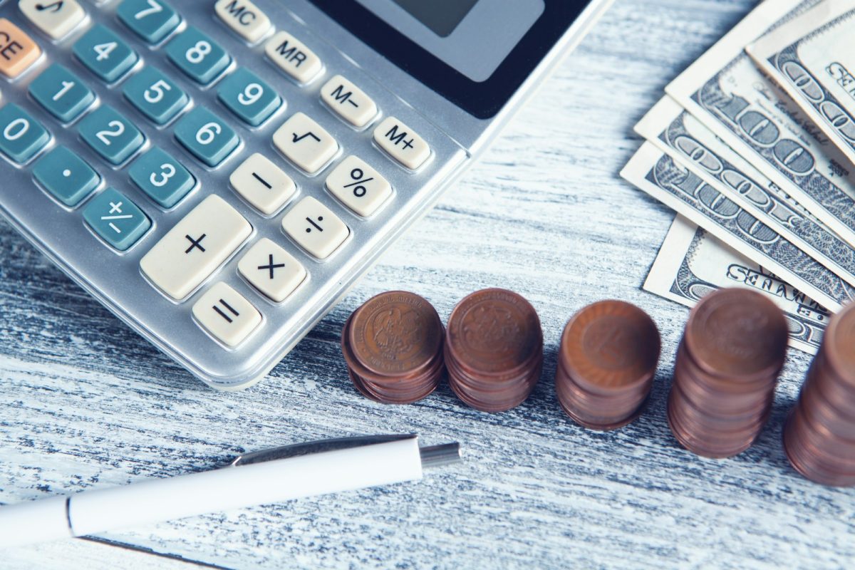 Direitos do trabalhador: calculadora, caneta e dinheiro para conferir verbas