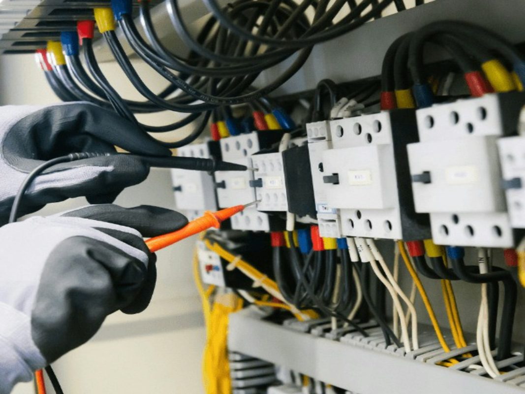 Eletricista testando painel elétrico com multímetro