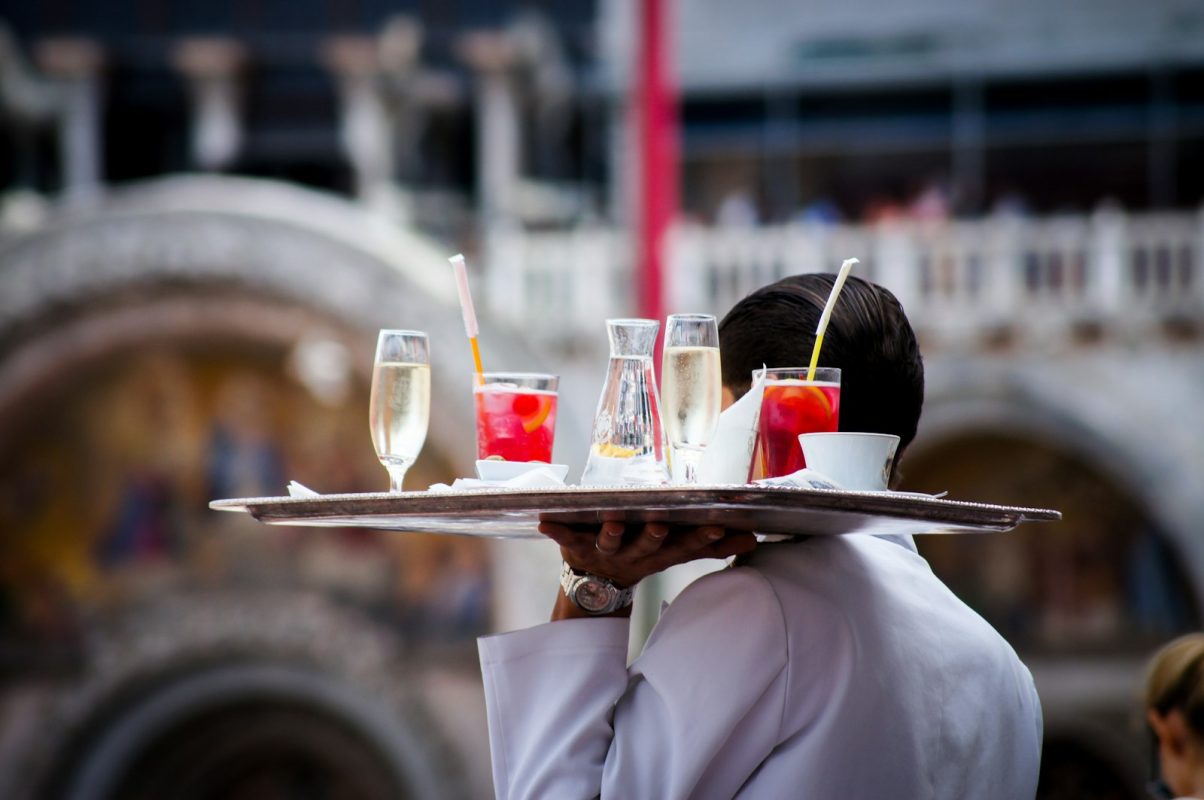 Garçom servindo bebidas no salão do restaurante