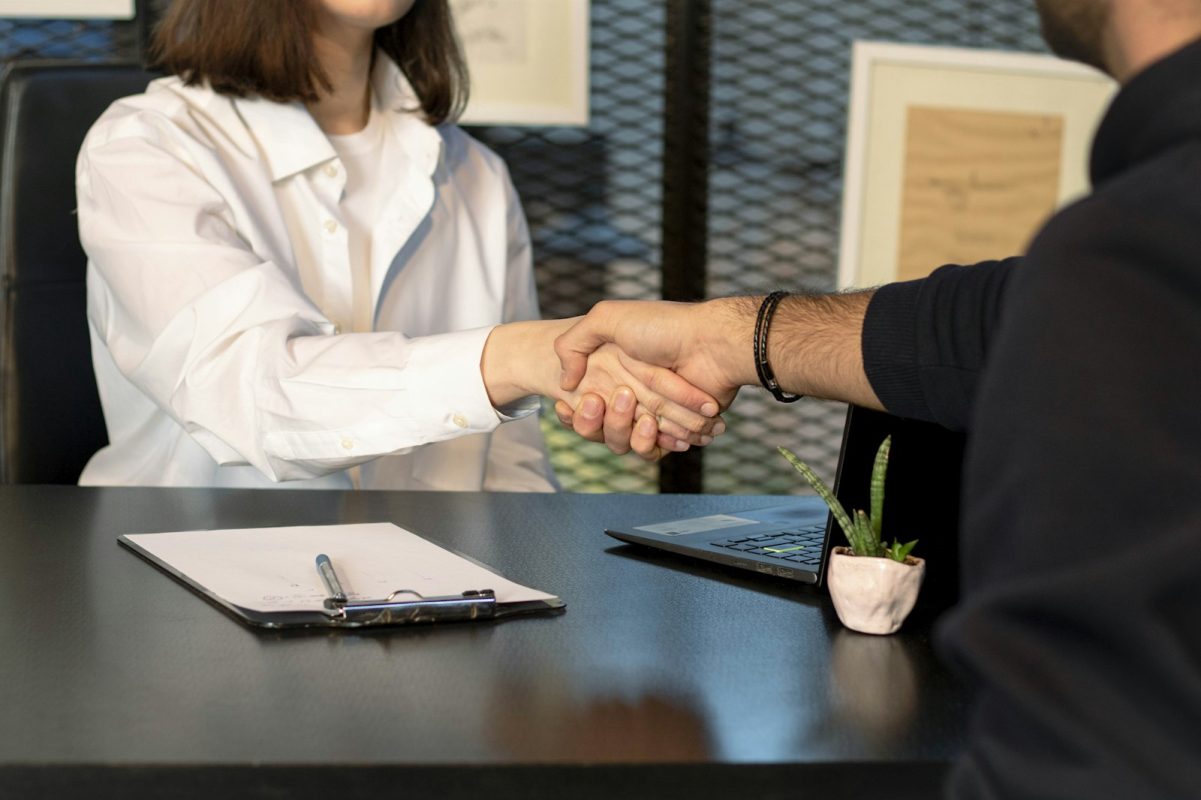 Candidato e recrutadora apertam as mãos ao fechar uma das melhores vagas de emprego