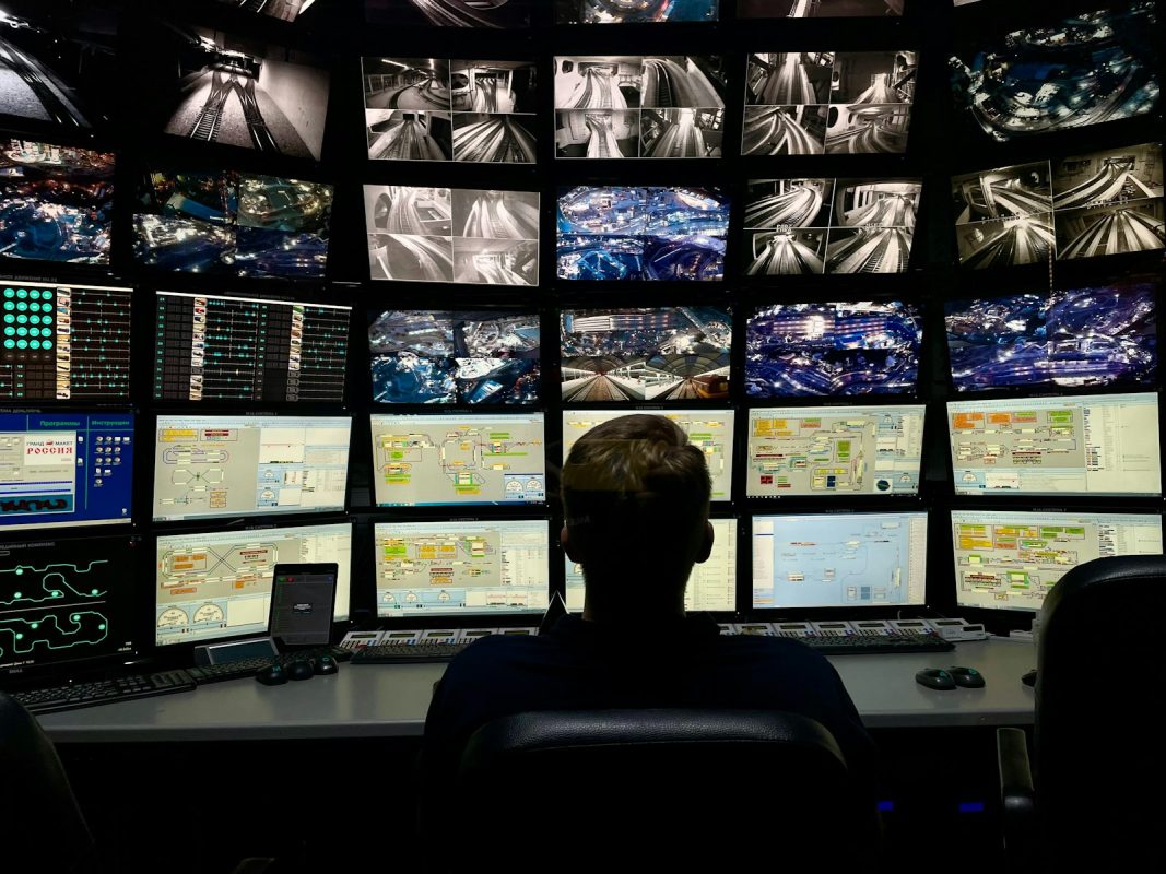 Porteiro sentado diante de vários monitores de câmeras