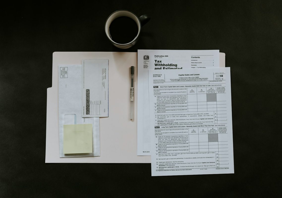 Seguro-desemprego: formulários, caneta e caneca de café sobre a mesa