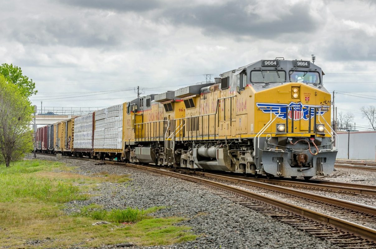 Locomotiva nos trilhos sob céu azul, carreira ferroviária nas vagas VLI